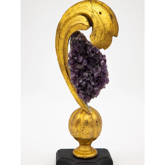 A reclaimed giltwood fragment on a stand. This reclamation art piece is finished with an amethyst at the crown. A lovely...