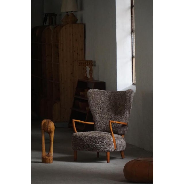 A beautiful Scandinavian high-wingback lounge chair from the 1950s, expertly crafted in oak and recently reupholstered in...