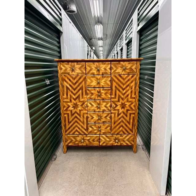 A substantial vintage craftsman chest of drawers with graphic parquetry star inlays, brass hardware, red stained sides and...