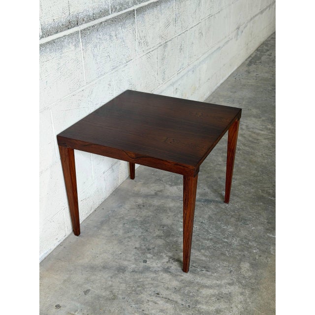 This square side table features a clean silhouette and an elegant minimalist profile. Slender tapered legs provide a...