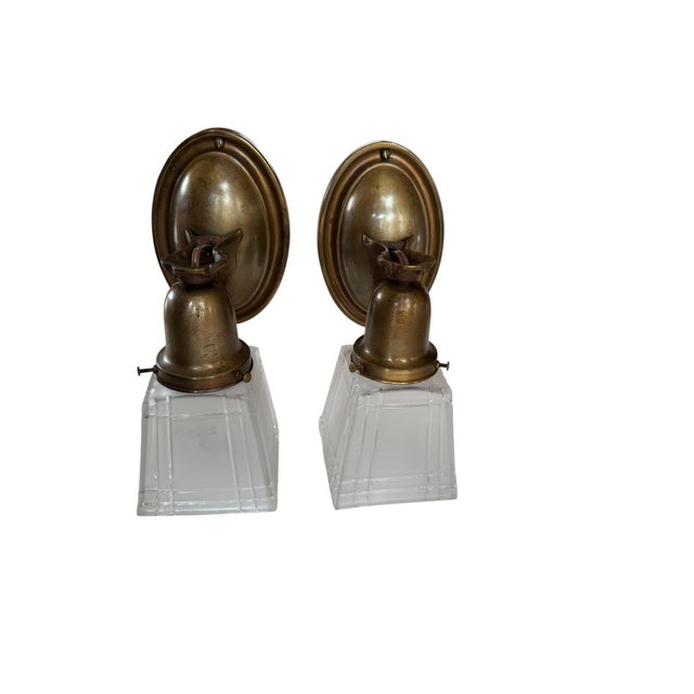 Great pair of antique brass wall sconces in an Arts & Crafts or Mission style, featuring oval backplates and square,...