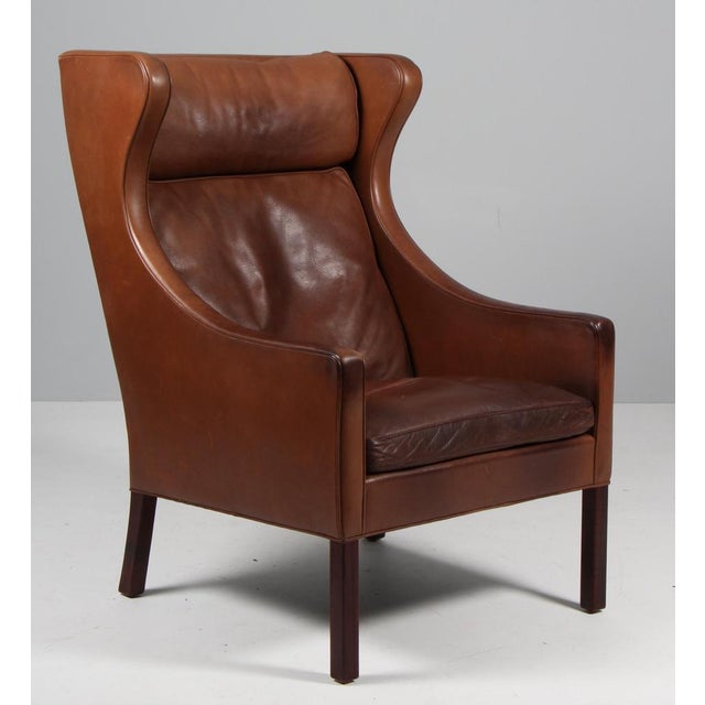 Børge Mogensen wingback chair in original patinated nature leather upholstery. Legs in teak. Model 2204, made by...