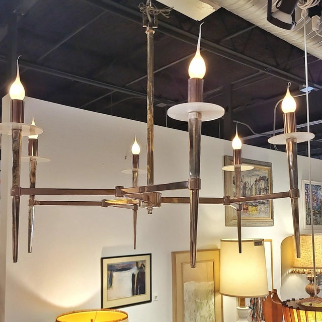 A modernist, six-arm chandelier of chromed aluminum with frosted lucite bobeches. Phenomenal. 30 ½'' DIAM. x 25'' H.