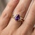 Embrace the majestic allure of this spectacular three-stone cocktail ring, blending a deep, regal color palette with a...
