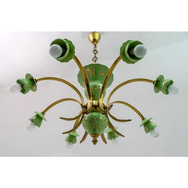 An elegant chandelier in the neoclassical style, eight lights, porcelain decorated in gold and gold-plated brass. Italian...