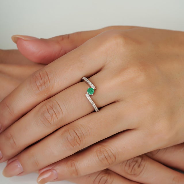 The minimalist hallmarked 925 silver round 0.29 ct emerald & diamond ring beautifully balances modern sculptural design...