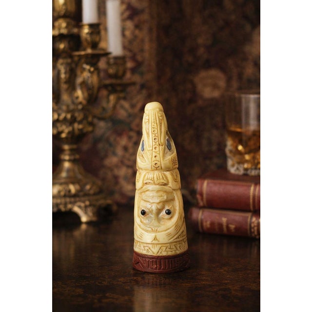 A sculptural antique cheroot holder carved in an ivory-toned bone material, circa 1900, with expressive figural detailing...