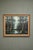 This large-scale vintage oil painting captures a serene forest scene with soft, diffused light breaking through towering...