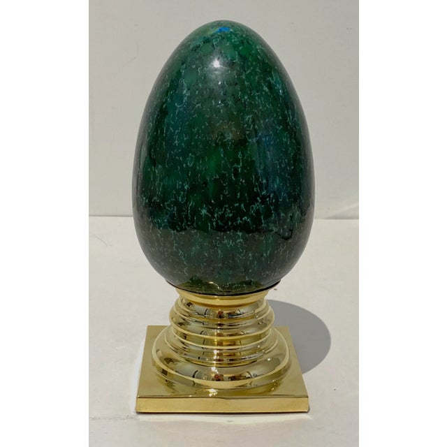 Eye-catching Porcelain Egg on polished brass stand -- glaze has a subtle random large crackle pattern and variegated hues....