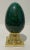 Eye-catching Porcelain Egg on polished brass stand -- glaze has a subtle random large crackle pattern and variegated hues....