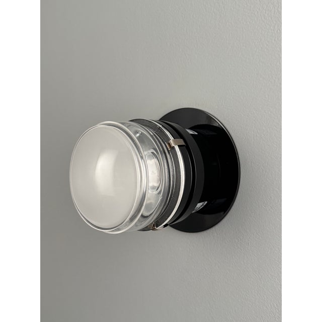 Joe Colombo Black 'Fresnel' Glass and Metal Indoor/Outdoor Wall Lamp for Oluce Executed in lacquered aluminum and thick...