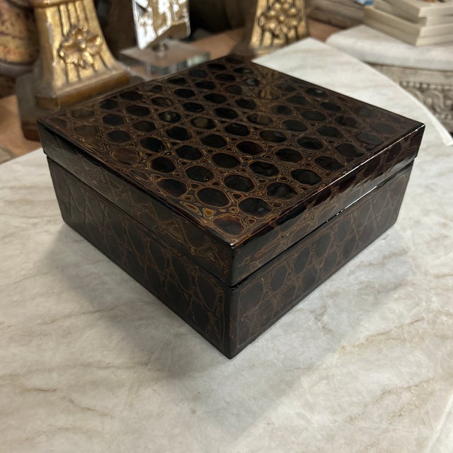 A supremely elegant black lacquer box decorated with delicate gold lines to create a honeycomb style pattern. These boxes...