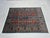 Bring rich color and intricate pattern to your home with this turquoise blue and red wool area rug. Six decorative red...
