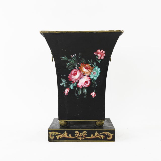 Elevate your decor with this elegant black metal cachepot, featuring a beautifully hand-painted floral motif. The pot is...