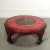 Gorgeous hand carved and painted low Asian cocktail table in red depicting a floral scene with abstract black accents....