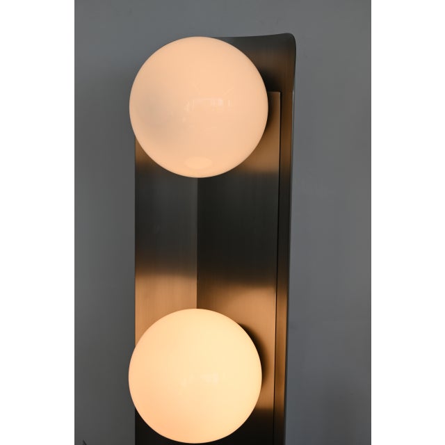 Tall and imposing postmodern floor lamp featuring a sculptural brushed stainless steel metal structure with two stacked...