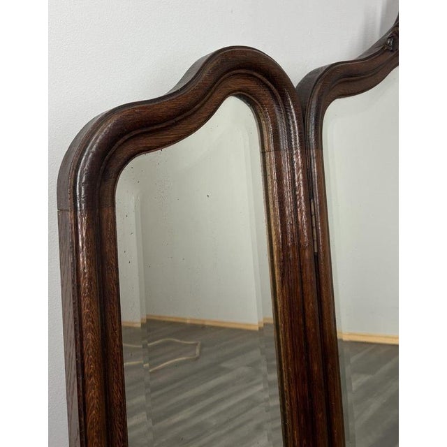 A striking Antique French rocaille mirror featuring a beautifully carved oak frame with an elegant triple-panel design....