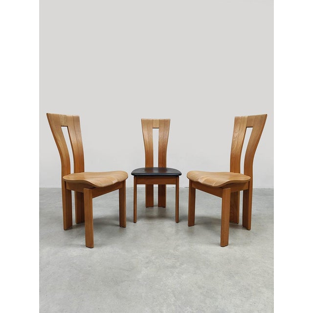 This set of vintage dining chairs is crafted from solid wood and shows influences from the work of Pierre Chapo from...