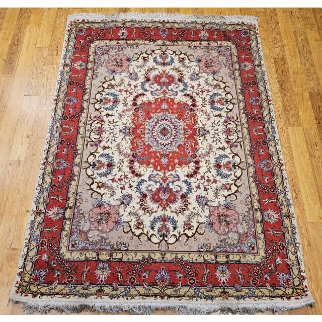 "This finely woven Persian Tabriz area rug from the late 1900s showcases the timeless elegance of the classic floral...