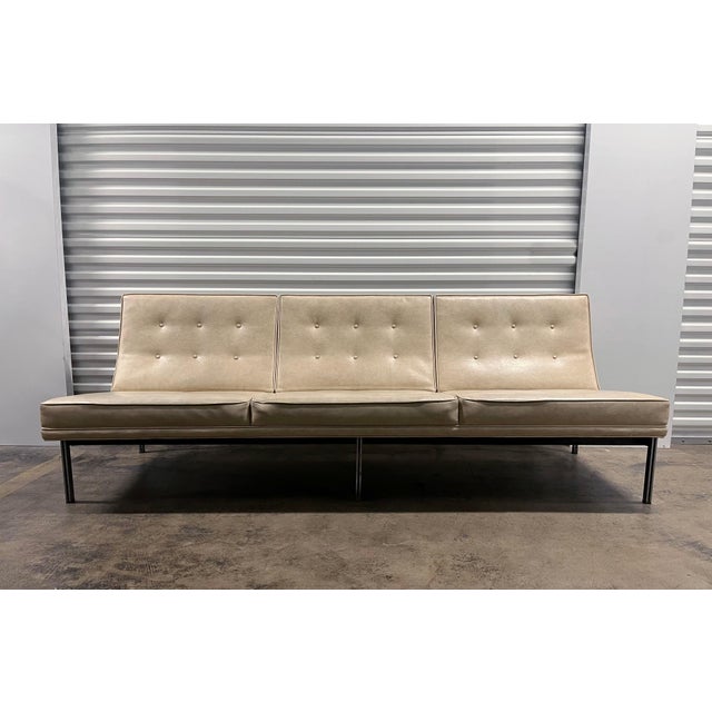 Florence Knoll Parallel Bar Sofa. This was reupholstered at one point in time in an off white faux leather vinyl. There...