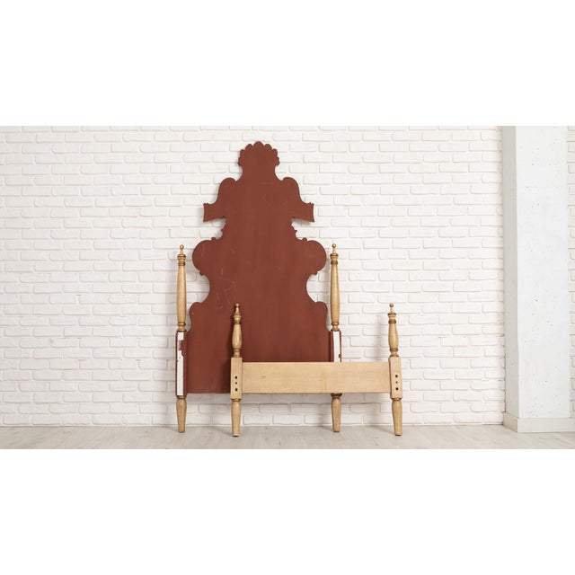 Decorative bed frame with a tall, shaped headboard and a lower footboard with turned posts. The headboard features a...