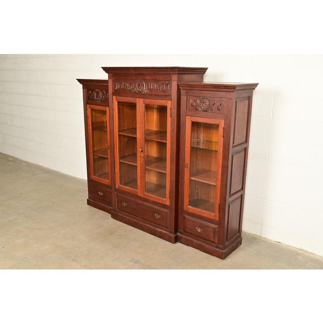 A gorgeous antique Victorian or Renaissance Revival triple bookcase cabinet or display cabinet In the manner of R.J....