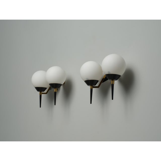 This pair of wall sconces exemplifies elegant and refined Italian design from the 1950s, attributed to Stilnovo. Crafted...