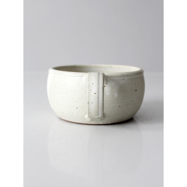 This vintage handmade studio pottery berry bowl features a softly rounded form with a creamy white speckled glaze and...