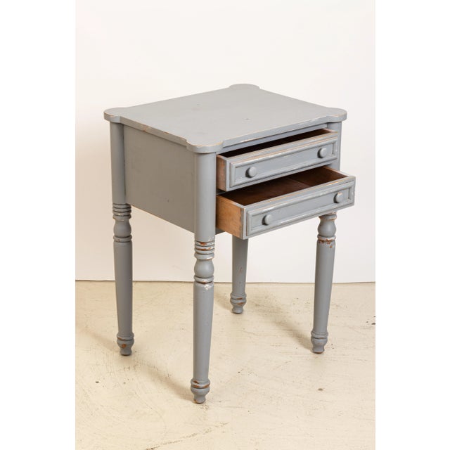 Grey painted two-drawer pine table with cookie cutter corners in a distressed finish, circa 1970s-1980s. Some wear to the...