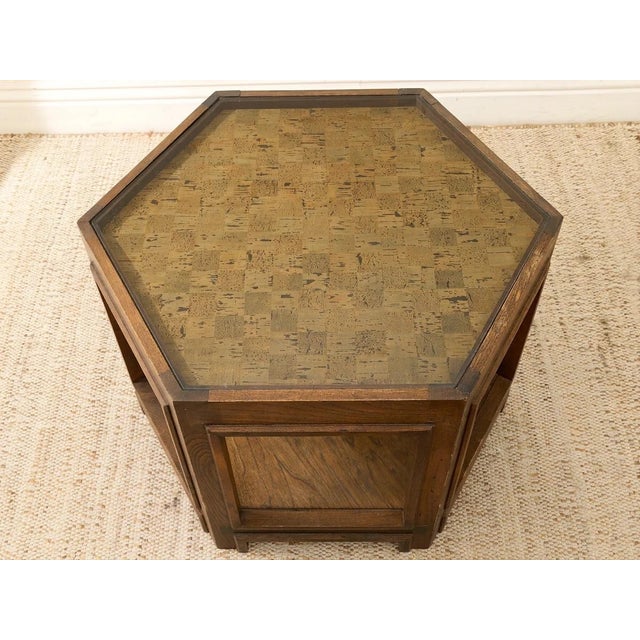 A handsome vintage side table with a geometric hexagonal silhouette and warm, richly grained wood construction. The inset...