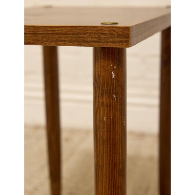 A handsome vintage side table with a warm wood finish, clean rectangular top, and simple tapered legs. Small round brass-...