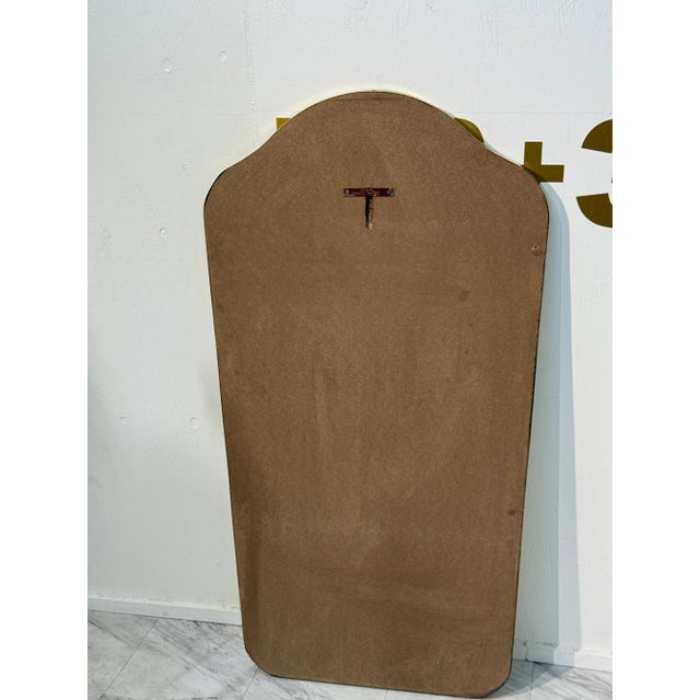 This is a vintage mid-century modern wall mirror featuring a gently contoured silhouette with soft curves at the top,...