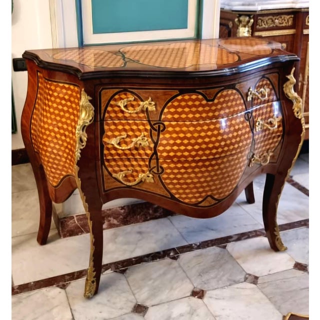 Make a sophisticated statement with this French Rococo-inspired bombe commode, featuring a beautifully curved silhouette,...