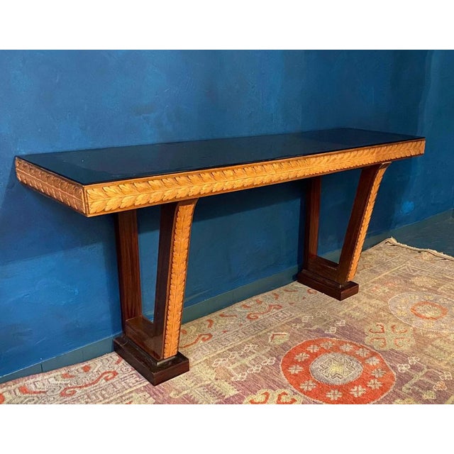Elegant and rare Italian designed console tables handcrafted finely carved in exotic woods and black glass top....