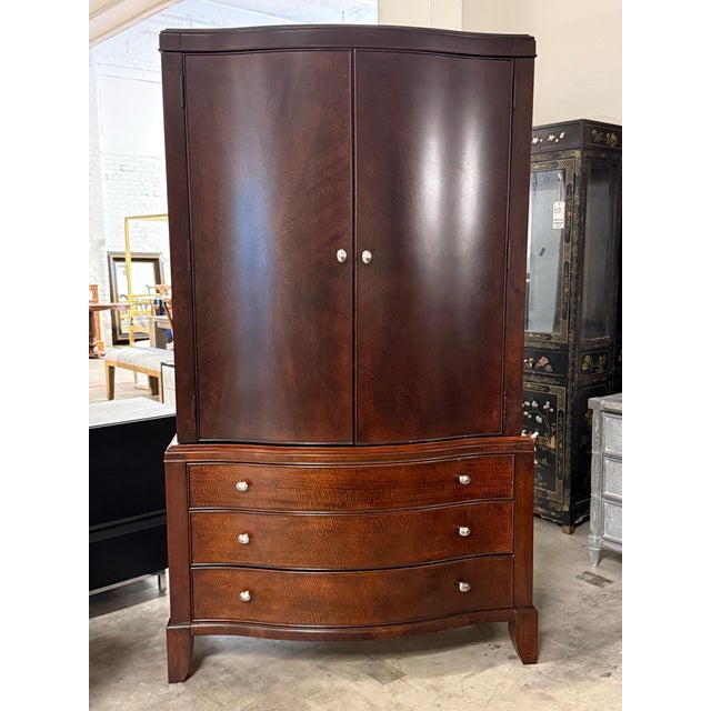 Design Plus Gallery presents a Dark Espresso Wood Media Armoire Cabinet. This two-door cabinet has an espresso-toned wood...