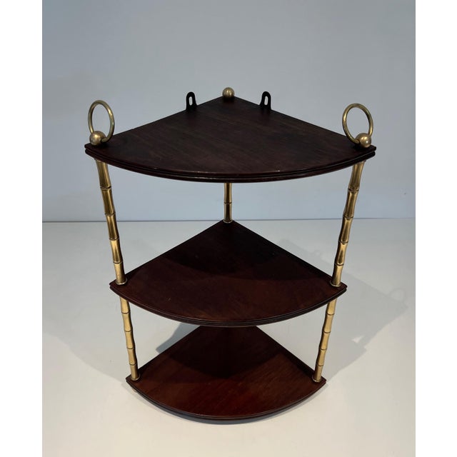 This beautiful corner shelf is made of faux-bamboo brass and mahogany. It is a French piece in the style of Maison Baguès....