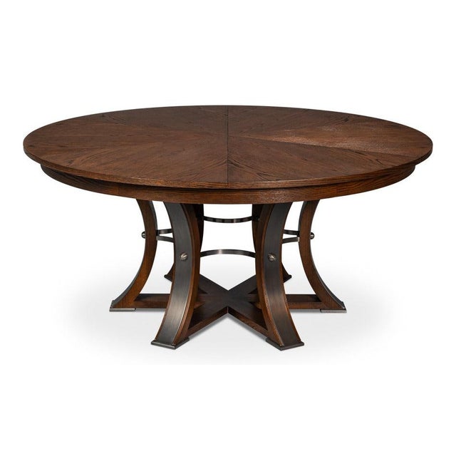 Warm brown oak and a sculptural, iron-detailed base give the expandable top a grounded presence. The deeper brown finish...