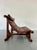 A heavy, sculptural sofa in the Brutalist tradition, with a solid wood frame that reads more like carved architecture than...