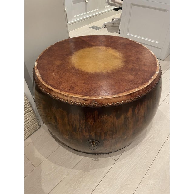 This is a Chinese-style natural wood drum coffee or side table with a stained leather top and brass nailhead trim. Hand-...