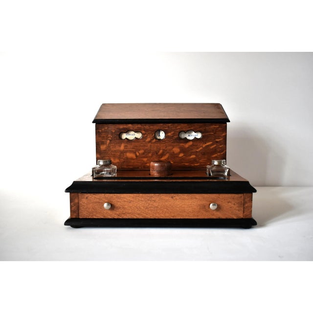 A Victorian, 19th-century stationery box desk accessory in tiger oak with black "ebonized" trim, comprised of an inkstand...