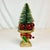 This is a pretty Bottle Brush Christmas Tree. It sits in a gold ceramic urn and is surrounded by red Christmas ornaments....