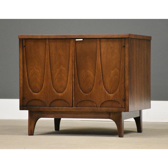 A mid century modern walnut nightstand by Broyhill Brasilia with swooping walnut details. Professionally refinished. Circa...