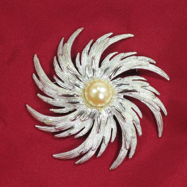 Vintage 1960s designer silver-plated mabe pearl brooch by Sarah Coventry. This oversize brooch offers a whirling design of...