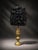 One-of-a-kind table lamp featuring an ornate antique gold-tone base with a dramatic black sculptural textured shade. The...