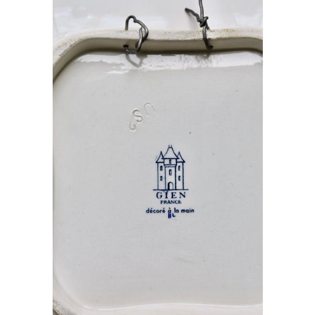 Square, shallow Gien earthenware dish, richly decorated with stylized flowers in shades of blue, red, and green, typical...