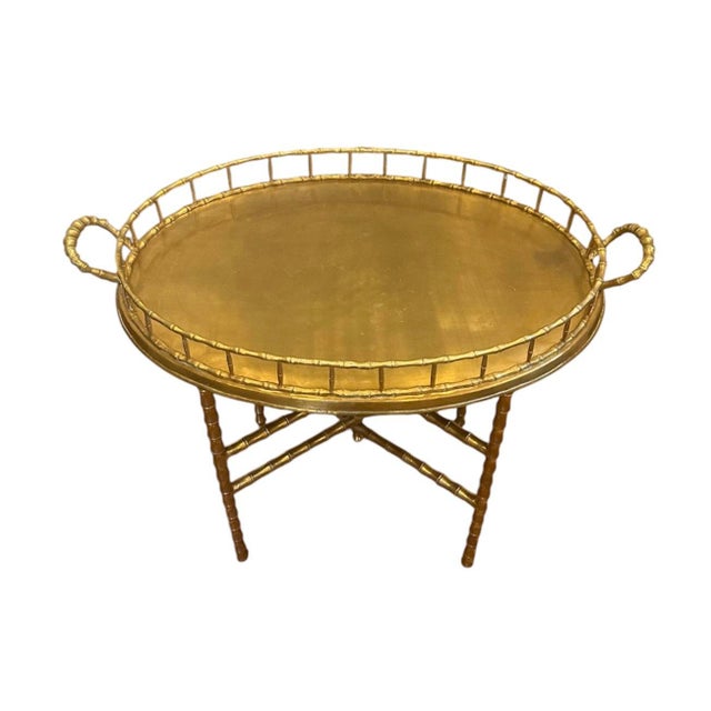 A lovely, vintage brass faux bamboo tray table. Features a large, brass oval tray embellished with a cast, faux bamboo...
