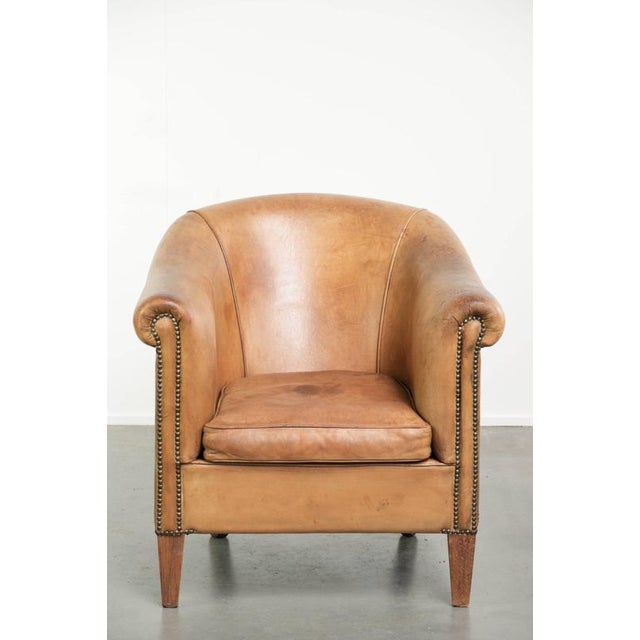 We are offering this distinctive sheepskin club armchair in a light cognac color, finished with decorative studs. This...