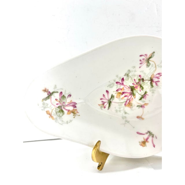 A beautiful antique Limoges porcelain bonbon dish featuring delicate hand-painted honeysuckle blossoms. The elegant...