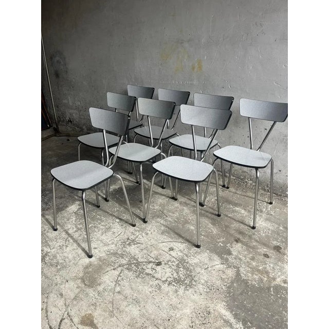 A charming set of 10 vintage dining chairs from the 1960s, showcasing a sleek and minimalist design. Their clean lines and...