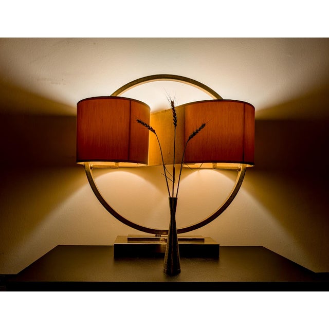 This large two-fixture contemporary transitional lamp features a single "continuous" faux silk shade, stainless steel or...